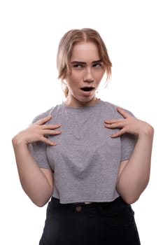 Surprised Caucasian fair-haired teenage girl in a gray T-shirt close-up.