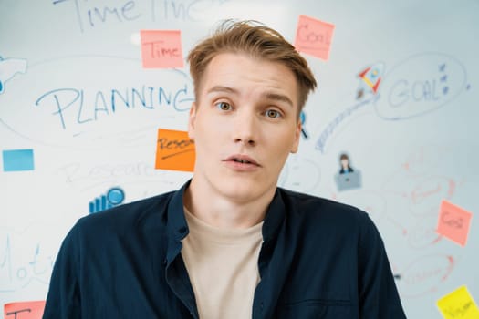 Portrait of young caucasian businessman shocked, surprised facial expression by receive good news. Stunning and amazing facial expression. Creative business meeting with mind map. Immaculate.