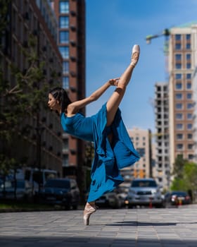 Beautiful Asian ballerina dancing outdoors. Urban landscape