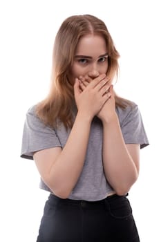 Fearful teenage girl with blond hair in a T-shirt on a white background.