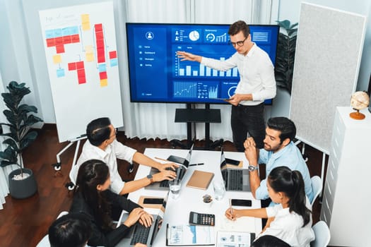 Presentation in office or meeting room with analyst team utilizing BI Fintech to analyze financial data. Businesspeople analyzing BI dashboard power display on TV screen for strategic planning.Prudent