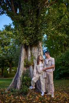 Young Cute Female Hugs Boyfriend. In Autumn Outdoor. Lovers Walking in Park. Attractive Funny Couple. Lovestory in Forest. Man and Woman. Cute Lovers in the Park. Family Concept. Happy Couple.