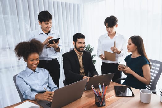 Happy diverse business people work together, discussing in corporate office. Professional and diversity teamwork discuss business plan on desk with laptop. Modern multicultural office worker. Concord