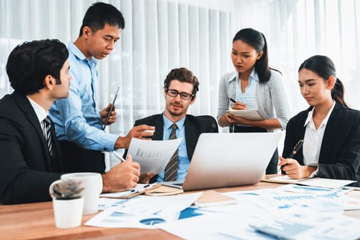 Diverse group of business analyst team analyzing financial data report paper on office table. Chart and graph dashboard by business intelligence analysis for strategic marketing planning Meticulous