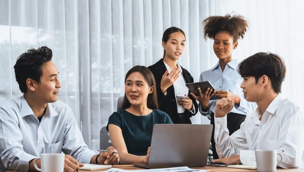 Happy diverse business people work together, discussing in corporate office. Professional and diversity teamwork discuss business plan on desk with laptop. Modern multicultural office worker. Concord