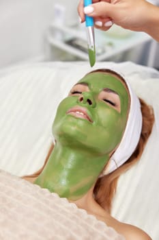 beautiful woman with green alginate mask on face