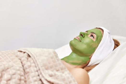 beautiful woman with green alginate mask on face