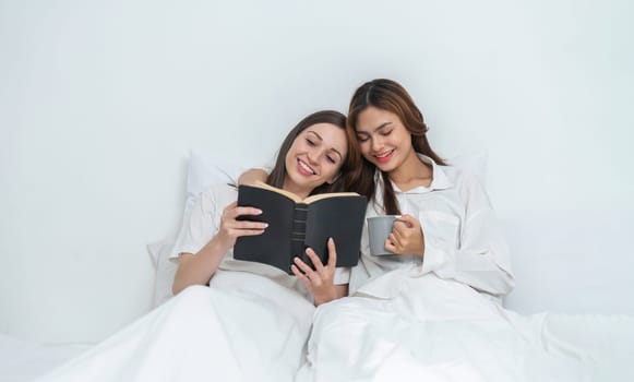 Young Asian lesbian couple sitting on bed during happy resting time Talk and relax in the bedroom..