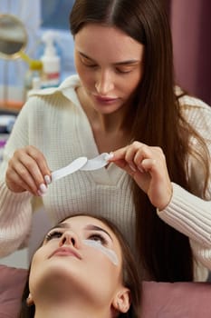 master preparing glue cotton tape under eye. Eyelash extension procedure