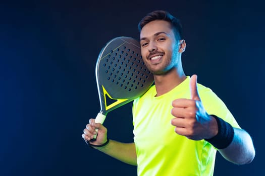 Padel tennis player with racket. Man athlete with racket on court with neon colors. Sport concept. Download a high quality photo for the design of a sports app or betting site