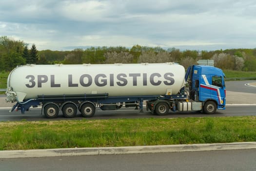 On a tank truck driving along the road there is an inscription - 3PL logistics. Logistics concept.