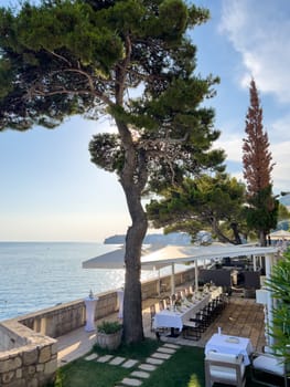 Laid festive table under a canopy on the terrace over the sea. High quality photo