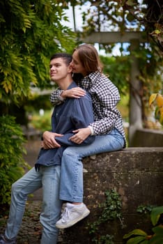 Young Cute Female Hugs Boyfriend. In Autumn Outdoor. Lovers Walking in Park. Attractive Funny Couple. Lovestory in Forest. Man and Woman. Cute Lovers in the Park. Family Concept. Happy Couple.