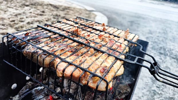 Pieces of shish kebab on iron grill over the coals over the grill. Delicious fried meat