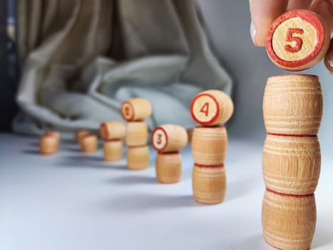 Small wooden barrels with numbers built in columns. The concept of duration and ways to achieve the goal. The sequence of actions to obtain the effect and result