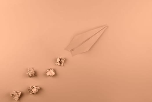 Trendy Color of the year 2024: peach fuzz, toned flat lay of paper plane