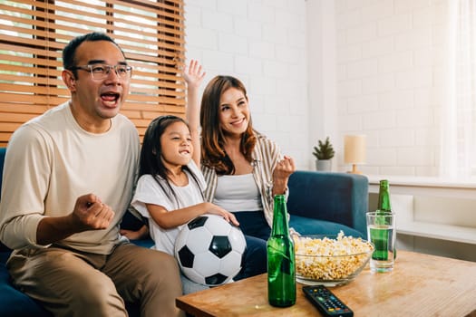 A happy family of fans enjoys watching a football match on TV at home, creating an atmosphere of togetherness and bonding. Their cheers and smiles reflect the joy of the game and shared happiness.