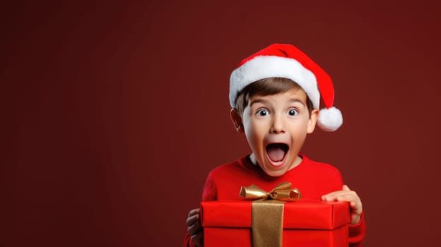 Surprised little boy in Santa Claus hat holding gift box. Christmas holidays. Boxing Day shopping. Holiday shopping.