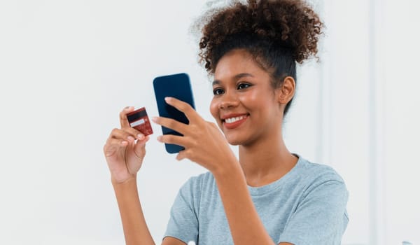 Young happy woman buy product by online shopping at home while ordering items from the internet with credit card online payment system protected by crucial cyber security from online store platform