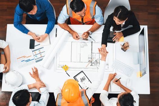 Top view banner of diverse group of civil engineer and client working together on architectural project, reviewing construction plan and building blueprint at meeting table. Prudent