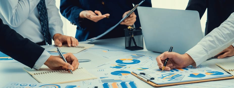 Business people in group meeting in formal attire share idea discussing report for company profit in creative workspace for start up business shot in close up view on group meeting table . Oratory .