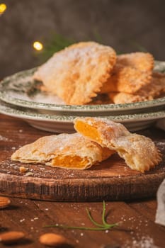 A crescent-shaped pastry whose filling is made of eggs and almonds wrapped in crispy dough, cut in an artisanal way and sprinkled with sugar.