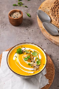 Delicious homemade creamy pumpkin soup with cream with sesame seeds and watercress.