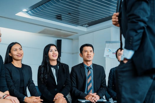 Young Asian and Caucasian audience sitting and listen to speaker in group meeting presentation at office. Businessmen and businesswomen in training workshop. International multicultural business. uds