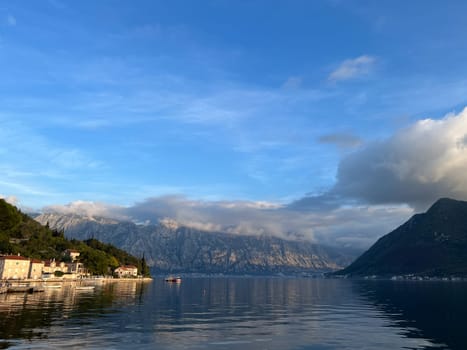 Perast embankment with moored fishing boats at the foot of the mountains. Montenegro. High quality photo