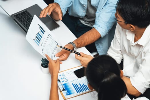 Analyst team utilizing BI Fintech to analyze financial data at table in meeting room. Businesspeople analyzing BI dashboard power on paper for business insight and strategic marketing planning.Prudent