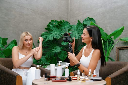 Two beautiful content creator making natural beauty and cosmetic tutorial on green plant garden video. Beauty blogger showing how to beauty care to social medial audience using selfie stick . Blithe