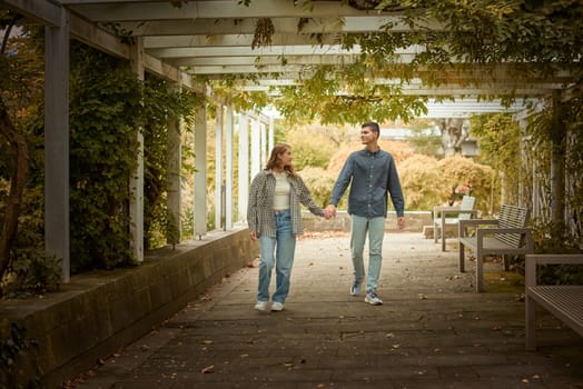 Young Cute Female Hugs Boyfriend. In Autumn Outdoor. Lovers Walking in Park. Attractive Funny Couple. Lovestory in Forest. Man and Woman. Cute Lovers in the Park. Family Concept. Happy Couple.