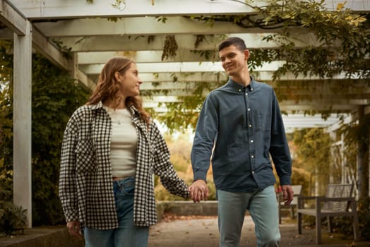 Young Cute Female Hugs Boyfriend. In Autumn Outdoor. Lovers Walking in Park. Attractive Funny Couple. Lovestory in Forest. Man and Woman. Cute Lovers in the Park. Family Concept. Happy Couple.