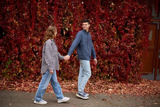 Young Cute Female Hugs Boyfriend. In Autumn Outdoor. Lovers Walking in Park. Attractive Funny Couple. Lovestory in Forest. Man and Woman. Cute Lovers in the Park. Family Concept. Happy Couple.