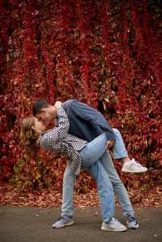 Young Cute Female Hugs Boyfriend. In Autumn Outdoor. Lovers Walking in Park. Attractive Funny Couple. Lovestory in Forest. Man and Woman. Cute Lovers in the Park. Family Concept. Happy Couple.