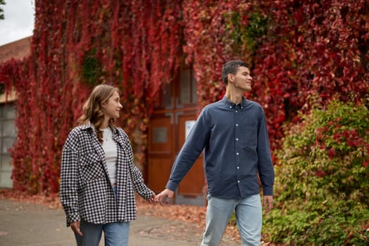 Young Cute Female Hugs Boyfriend. In Autumn Outdoor. Lovers Walking in Park. Attractive Funny Couple. Lovestory in Forest. Man and Woman. Cute Lovers in the Park. Family Concept. Happy Couple.