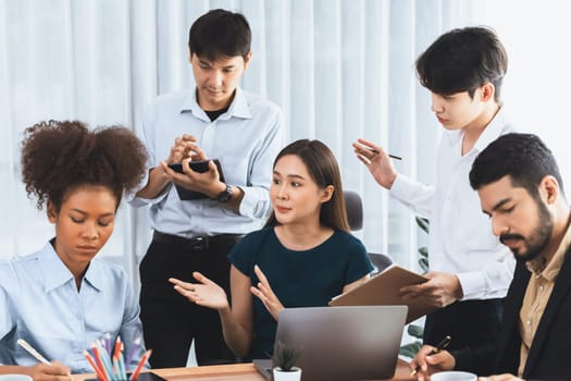 Happy diverse business people work together, discussing in corporate office. Professional and diversity teamwork discuss business plan on desk with laptop. Modern multicultural office worker. Concord