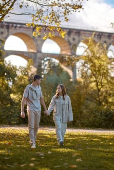 Young Cute Female Hugs Boyfriend. In Autumn Outdoor. Lovers Walking in Park. Attractive Funny Couple. Lovestory in Forest. Man and Woman. Cute Lovers in the Park. Family Concept. Happy Couple.