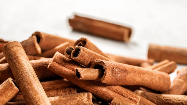 Pile of organic cinnamon bark, selective focus photo - only few sticks in focus