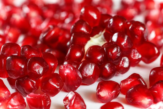 Closeup of pomegranate fruit gem like berries on white board