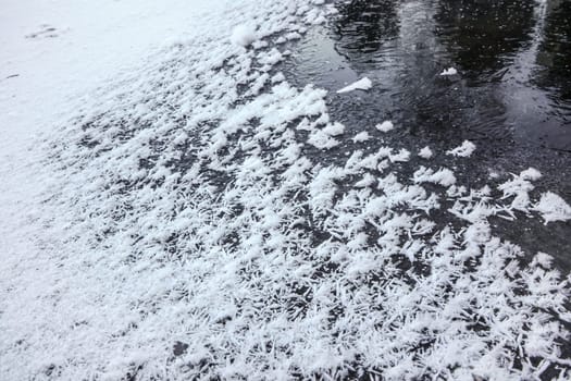 Crystalline snow on frozen pond ice, abstract winter background