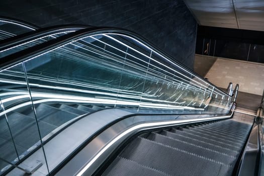 Looking down futuristic escalator moving stairs in modern offices