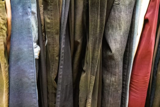Closeup of old Jeans and trousers displayed at thrift shop