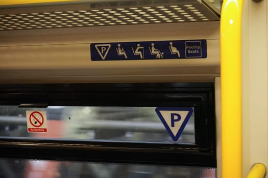 Priority seats and no smoking sign above window of London train