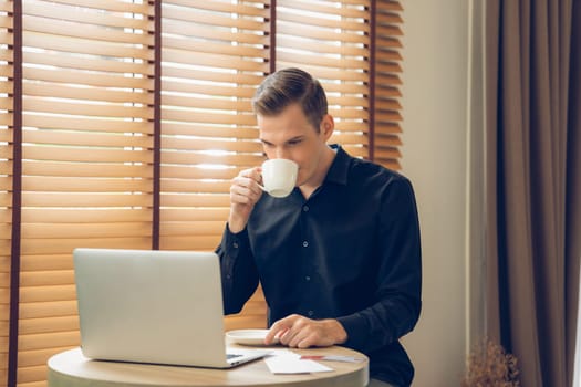 Happy businessman doing online business, remote working, trading at coffee cafe. College man study using laptop for educational master of business administration online course. Unveiling