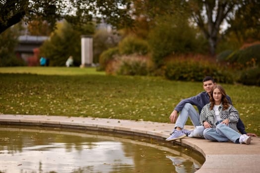 lovely young couple kissing outdoors in autumn. Loving couple walking in nature. Autumn mood. Happy man and woman hugging and kissing in autumn. Love. Fashionable couple outdoors. Fashion, people and lifestyle. Stylish couple in autumn outfit.