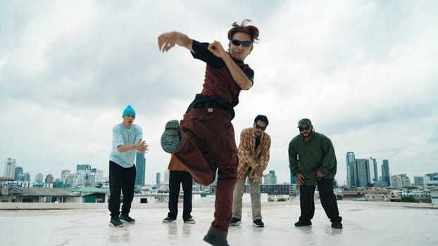 Professional asian street dancer practice B boy dance while multicultural friends at roof top. Young modern dancing group doing hip hop movement. Style,fashion,action. Outdoor sport 2024. Endeavor.