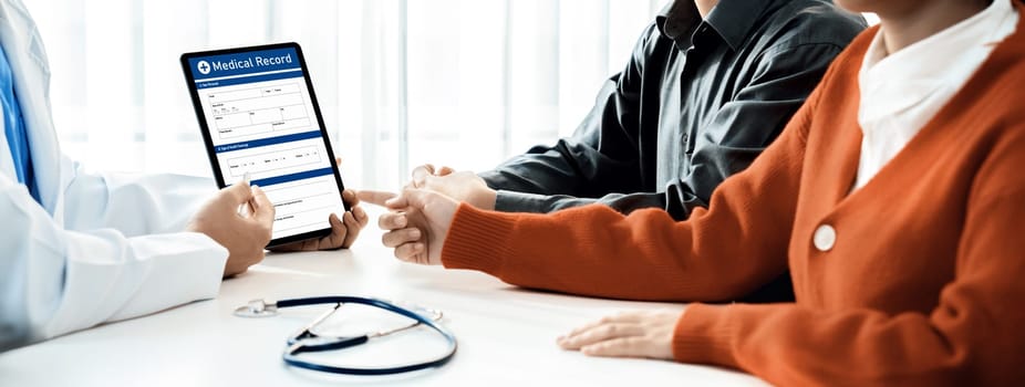 Couple attend fertility consultation with gynecologist at hospital as part family planning care for pregnancy. Loving husband and wife support each other through the doctor appointment. Panorama Rigid