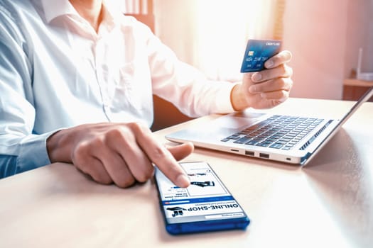 Young man use credit card for shopping payment online on laptop computer application or website. E-commerce and online shopping concept. uds