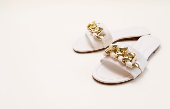 Mockup White Beige Female Eco-leather Sandals With Golden Buckle Chain. Fashion, Summer Footwear, Shoes For Woman. National Shoe The World Day. Pastel Beige Background, Copy Space For Text, Horizontal